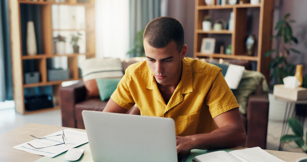 Jeune de 18 ans devant un ordinateur, sur la page d'accueil du site impots.gouv.fr pour créer son espace personnel.