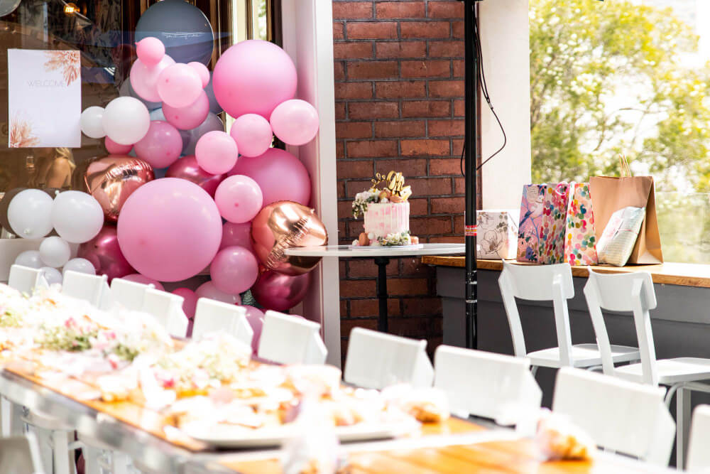 Table de banquet dressée pour un grand anniversaire, avec des ballons.