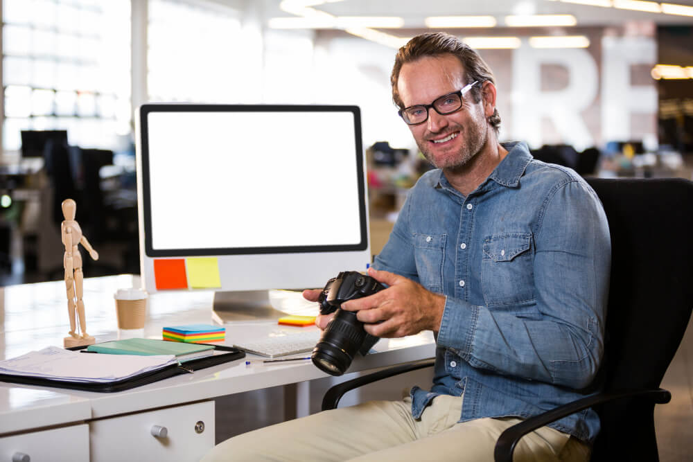 Manager prenant en photo l'écran d'ordinateur ou le poste de travail d'un salarié.