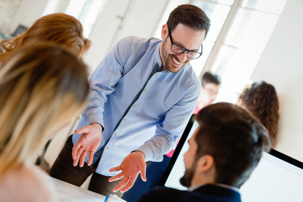 Les 5 soft skills indispensables à développer via une formation en management moderne 2 Un manager bienveillant à l'écoute de son équipe lors d'un point de suivi en entreprise.