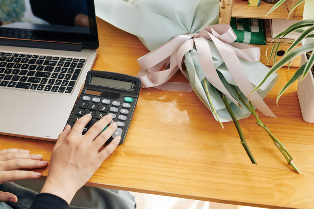 Anticiper un grand événement familial : l'astuce pour épargner sereinement 2 Une personne calculant sur son ordinateur le budget nécessaire pour organiser une grande fête de famille.