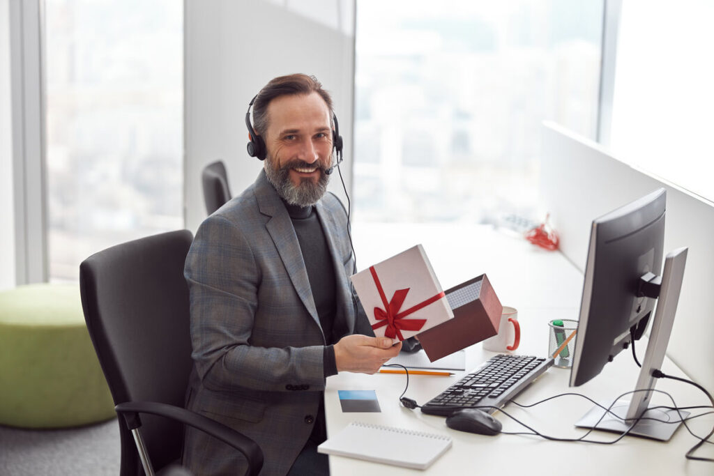 Un client ouvrant un coffret cadeau d'affaires premium envoyé par une entreprise partenaire.