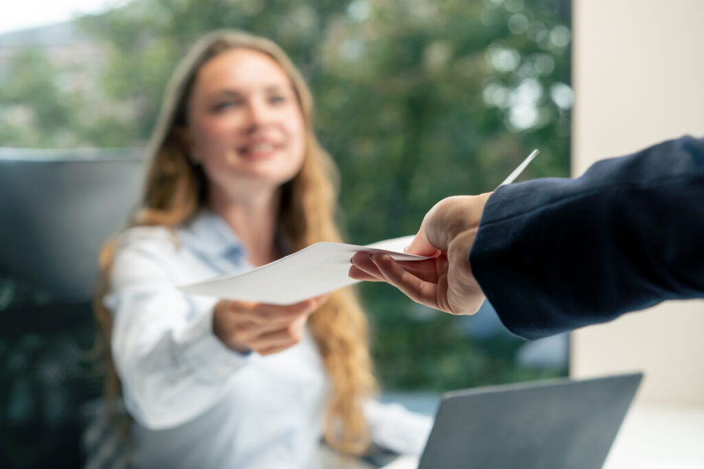 Une salariée remettant en main propre sa lettre de démission à son responsable lors d'un entretien.
