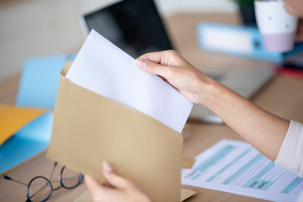 Enveloppe et lettre de démission officielle prêtes à être envoyées en recommandé.