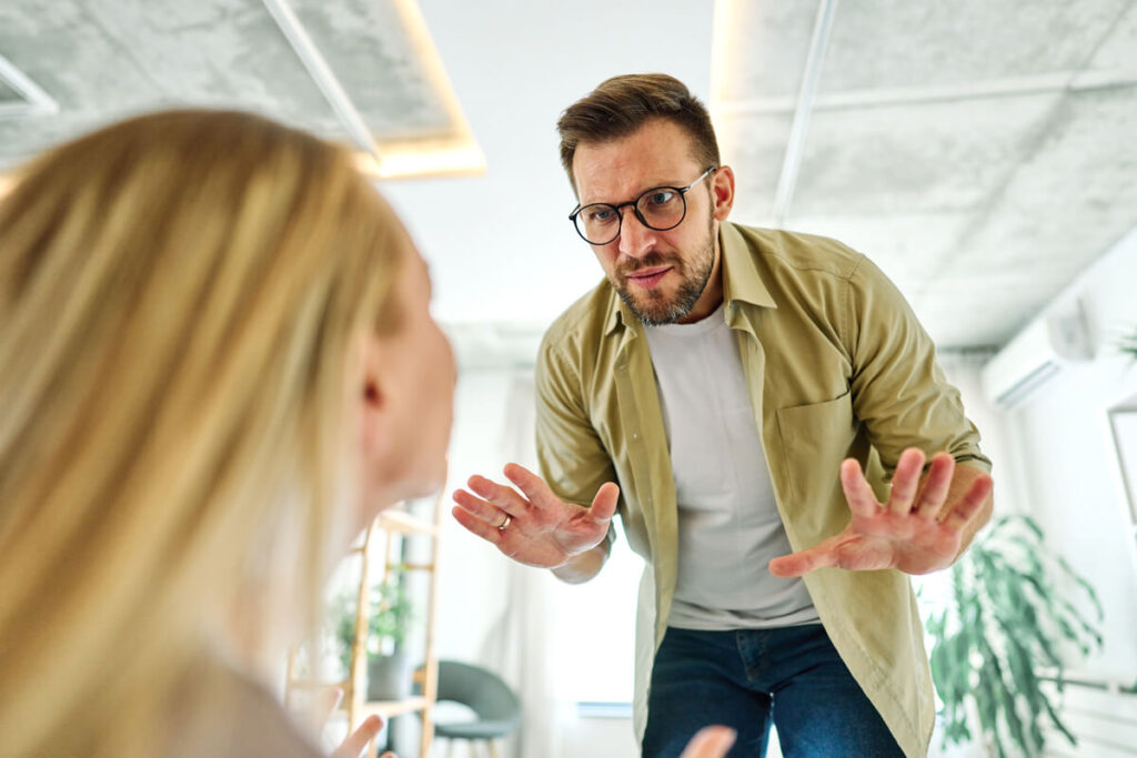 Un salarié face à un employeur agressif, illustrant une situation de communication toxique.