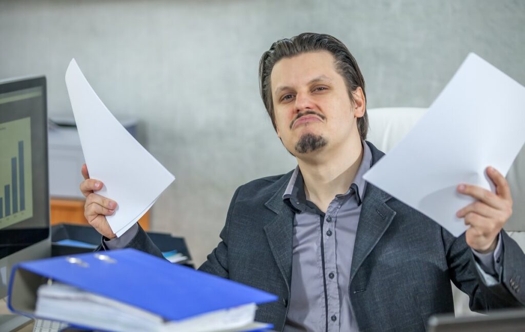 Un salarié examinant attentivement les lignes de classification et de coefficient en haut de sa fiche de paie.