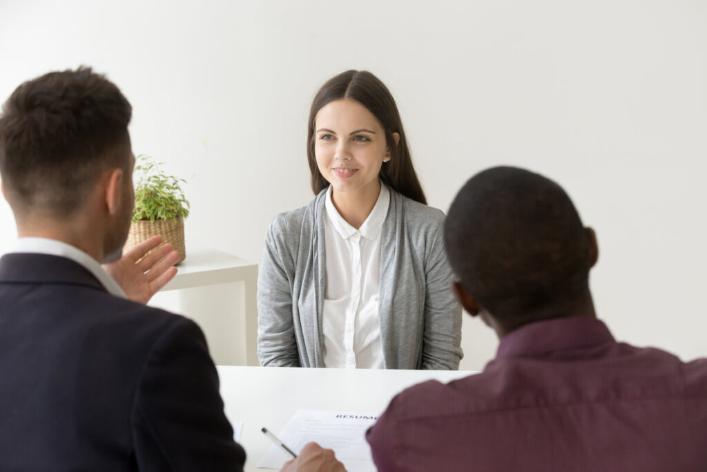 Une chargée de recrutement évaluant les compétences linguistiques orales d'un candidat lors d'un entretien en face-à-face.