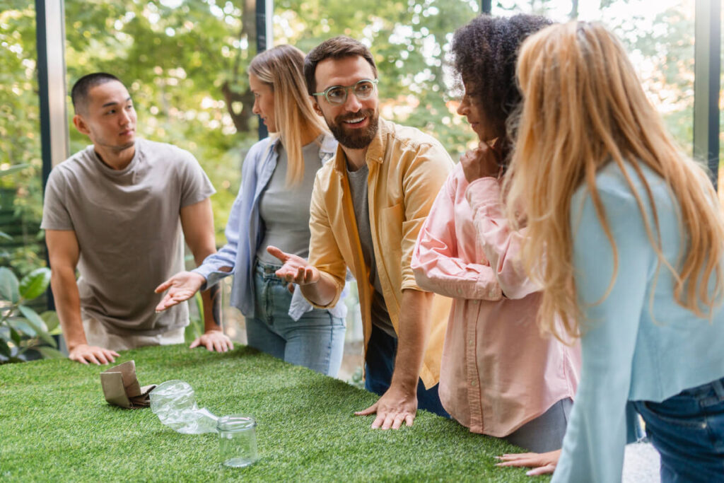 Des salariés souriants échangeant de manière informelle lors d'un moment de détente en plein air durant un séminaire.