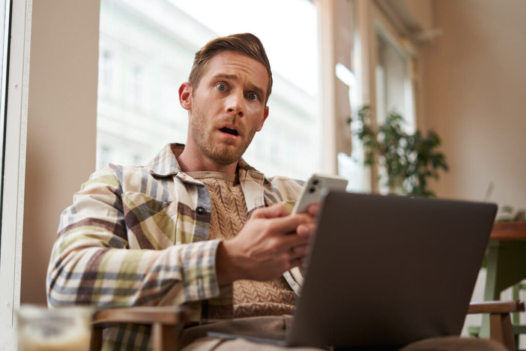 Une personne constatant avec surprise un débit suspect non autorisé sur son application bancaire mobile.