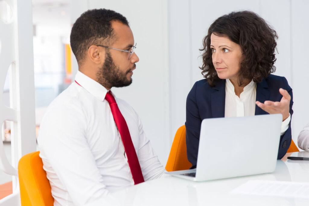Un salarié et une responsable des ressources humaines en pleine discussion lors d'un entretien de rupture conventionnelle.