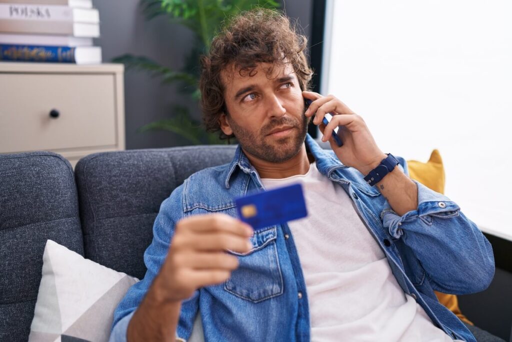 Un client contactant d'urgence le service d'opposition de sa banque pour bloquer sa carte de paiement.