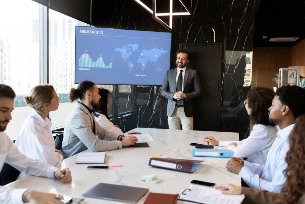Séminaire d'entreprise : un investissement stratégique pour la performance et la rétention des talents 7 Un comité de direction présentant les objectifs annuels et la stratégie de croissance dans une salle de conférence.