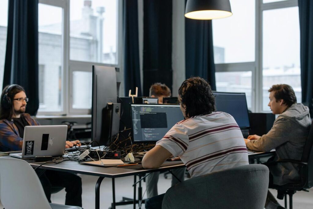 Des étudiants en reconversion travaillant en équipe sur un projet de code chez La Capsule.
