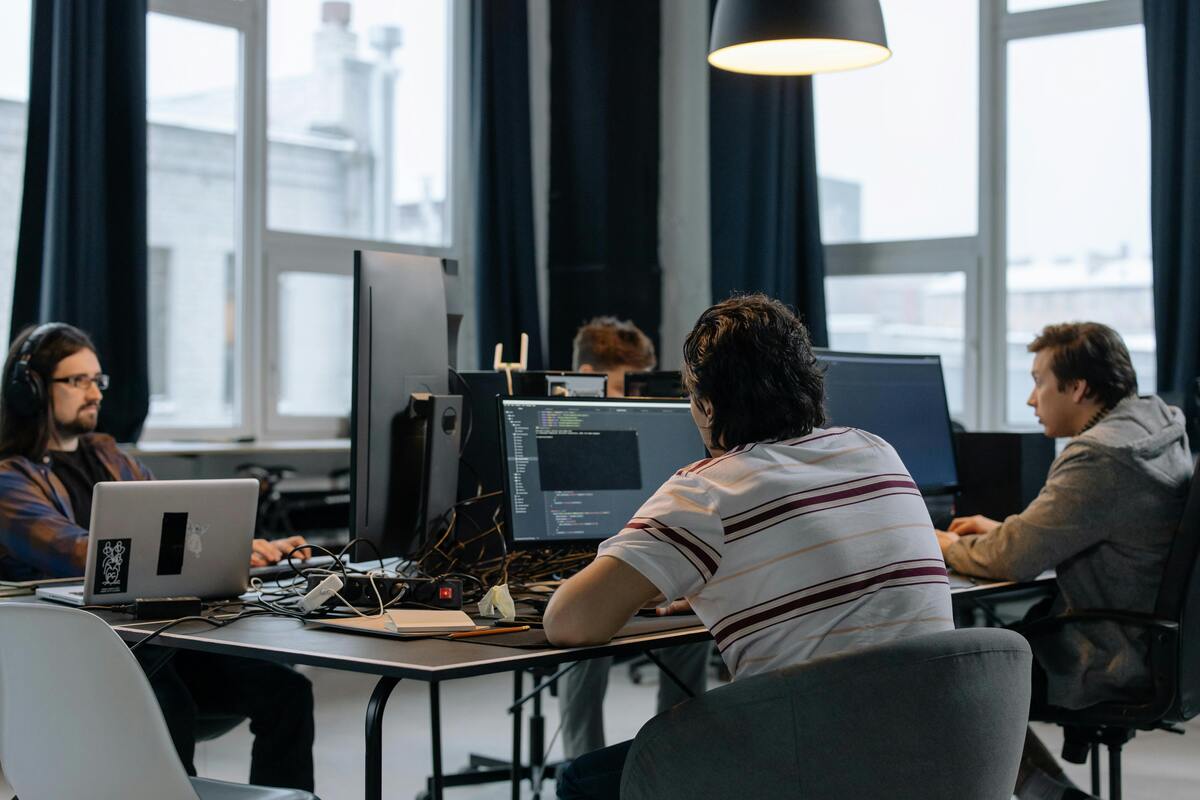 Des étudiants en reconversion travaillant en équipe sur un projet de code chez La Capsule.