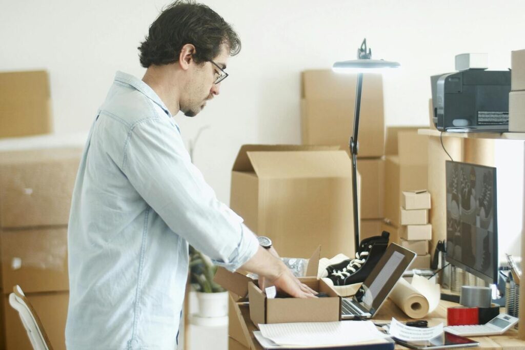 Rupture conventionnelle et déménagement : ce que vous pouvez vraiment obtenir 2 Des cartons de déménagement empilés à côté d'un bureau de travail en entreprise.