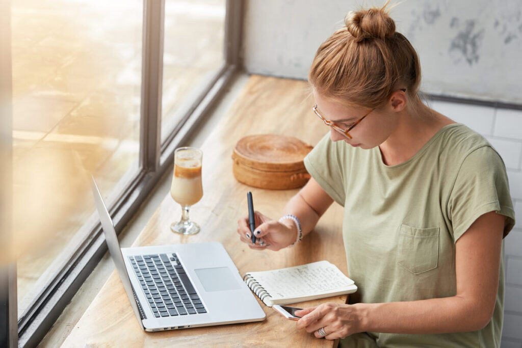 Un collaborateur écrivant ses nouvelles aspirations professionnelles sur un carnet à la maison.