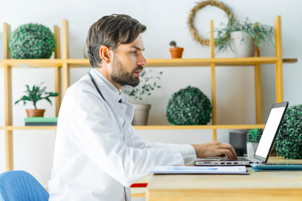 Un professionnel de santé vérifiant ses relevés de télétransmission et ses bordereaux AMC sur son écran d'ordinateur.