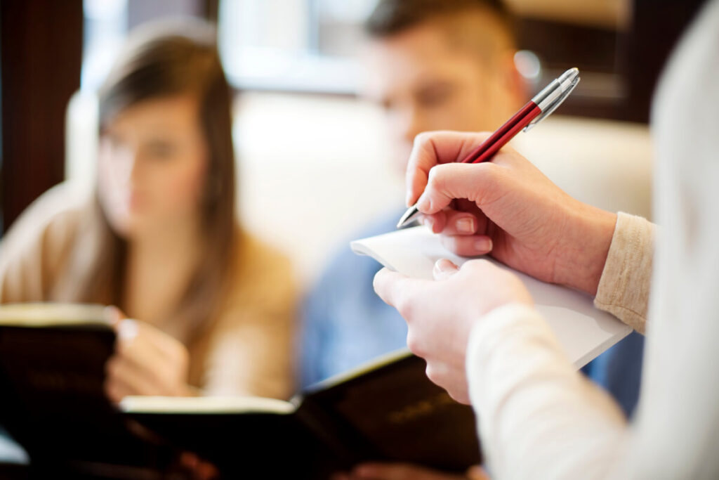 Un participant signant la feuille de présence officielle à l'accueil avant l'ouverture d'une assemblée générale.