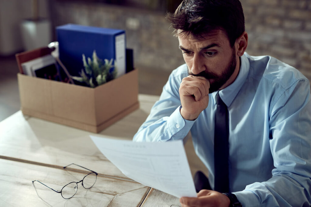 Un conjoint inquiet consultant des courriers de relance d'organismes de crédit à la consommation découverts à la maison.