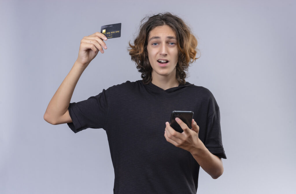 Carte bancaire pour mineur : comprendre les solutions adaptées aux jeunes 4 Un jeune analysant ses économies et ses dépenses mensuelles sur l'écran de son smartphone.