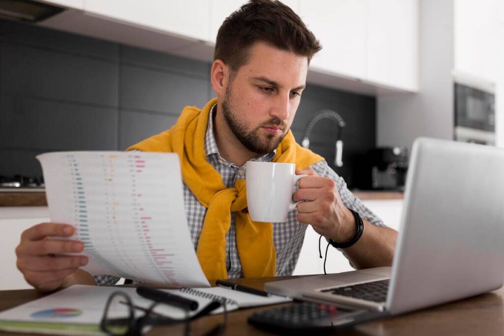 Sécuriser ses revenus en freelance : la solution du portage salarial 3 Un indépendant analysant sa fiche de paie mensuelle délivrée par sa société de portage.