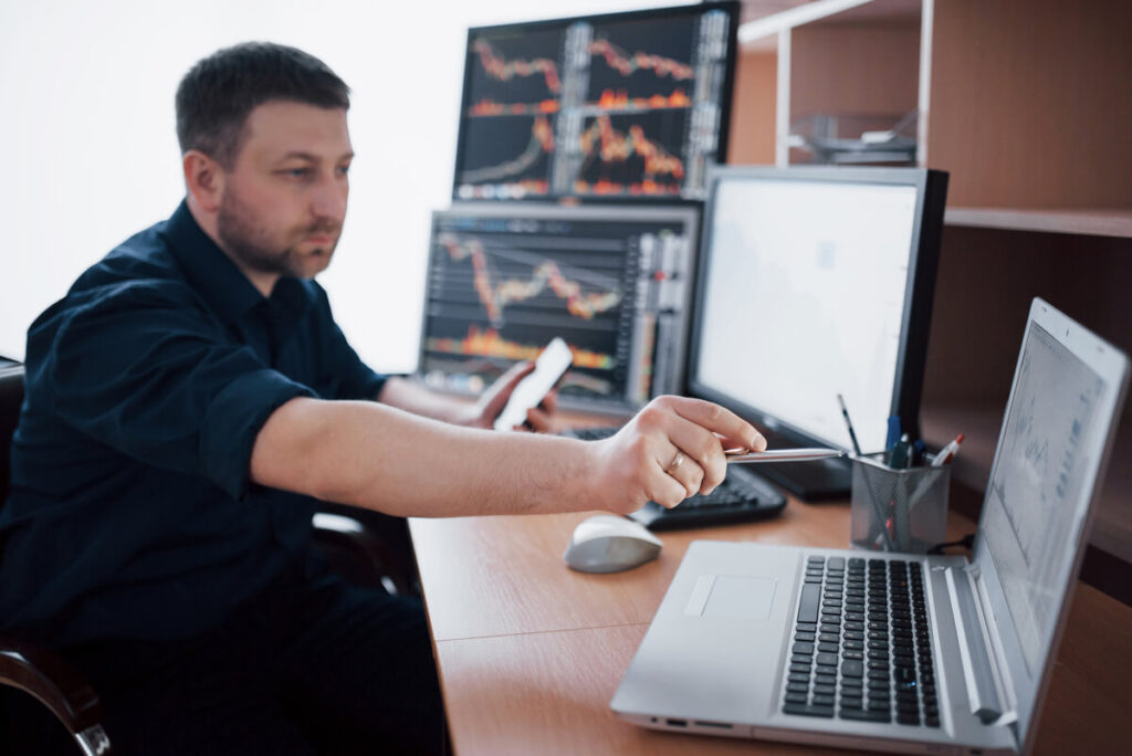 Investir sur les marchés actions américains avec un PEA : une stratégie souvent méconnue des investisseurs 4 Un épargnant consultant un guide comparatif des meilleurs PEA et des frais de courtage sur une tablette tactile.