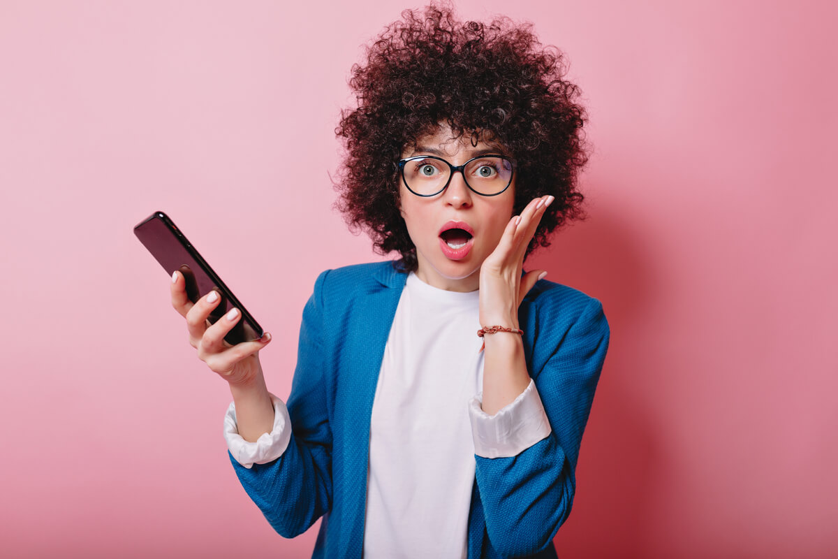Une personne consultant ses comptes en ligne sur son smartphone, surprise par une ligne de débit.