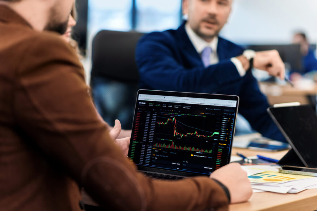 Investir sur les marchés actions américains avec un PEA : une stratégie souvent méconnue des investisseurs 2 Un investisseur analysant les performances des indices boursiers S&P 500 et Nasdaq via des ETF éligibles au PEA sur son écran.