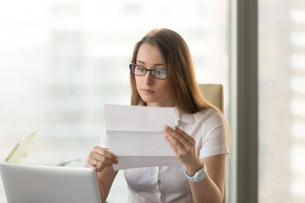 L'offre « Compte à composer » du Crédit Agricole est-elle obligatoire ? 3 Une personne rédigeant un courrier recommandé pour résilier des options bancaires payantes.