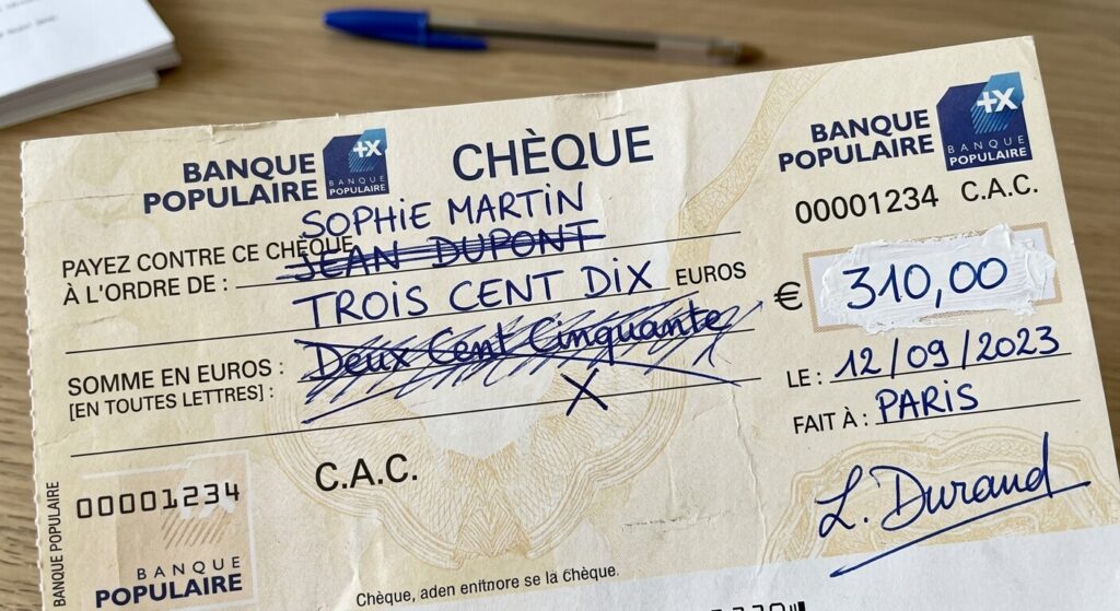 Un chèque bancaire comportant des ratures ou du blanc correcteur.