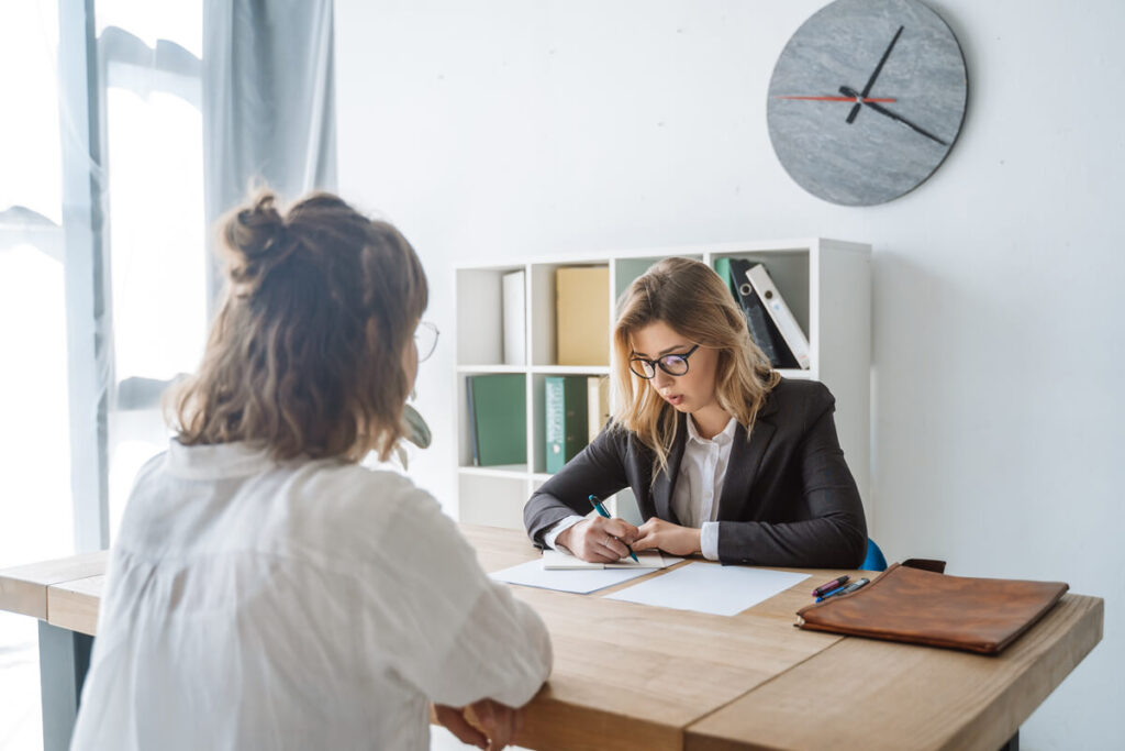 Fin de droit AAH et demande de RSA : démarches et bascule des aides 3 Un allocataire discutant de ses droits administratifs avec une conseillère à son bureau.