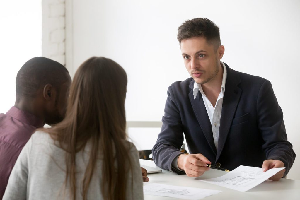 Avocat en droit des affaires expliquant les risques et obligations d'un contrat de cautionnement à son client.