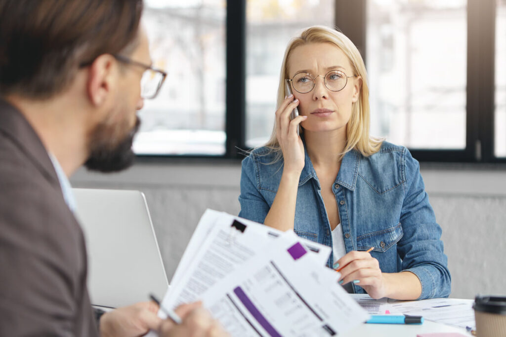 Consultant et client examinant les clauses de durée et de résiliation d'un contrat de prestation.