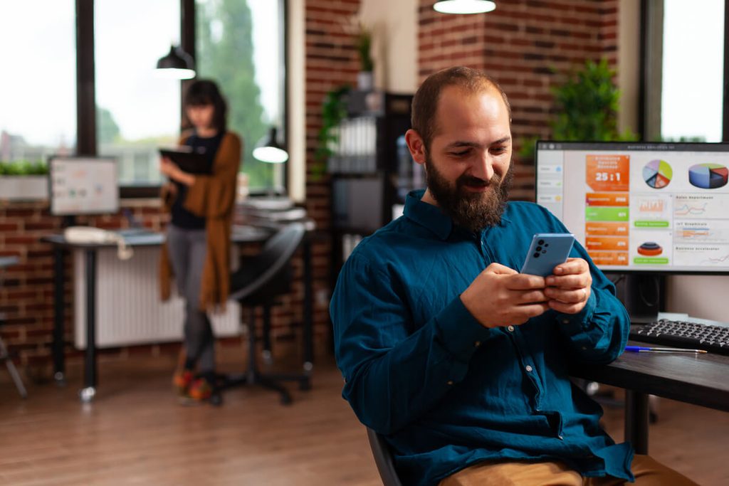 RCS vs SMS : comment la messagerie enrichie transforme la communication de marque 3 Responsables marketing analysant les taux d'engagement d'une campagne de messagerie RCS de marque.