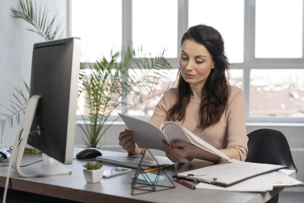 Gestionnaire RH vérifiant les bulletins de paie de l'entreprise avant validation.