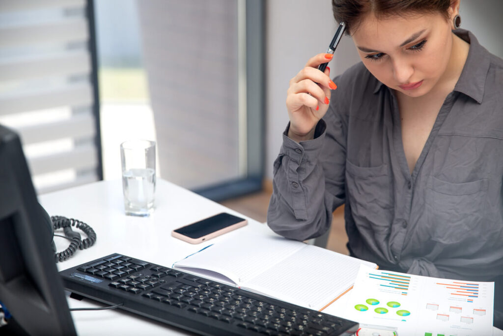 Créer son entreprise : quel budget prévoir pour ses assurances au démarrage ? 2 Créateur d'entreprise calculant le budget des assurances professionnelles sur un tableau prévisionnel financier.