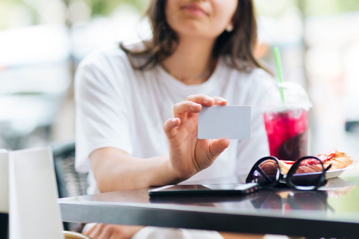 Salarié tenant une carte de titres-restaurant au moment de la pause déjeuner en entreprise.