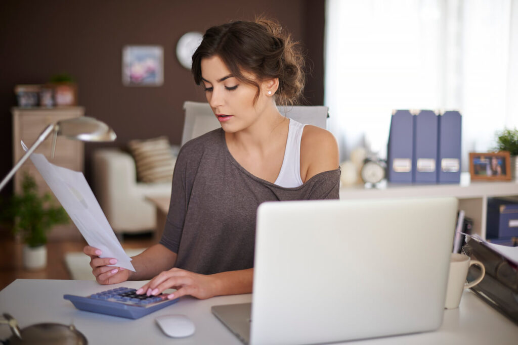 Travailleur indépendant freelance examinant sa déclaration fiscale et ses revenus sur son ordinateur portable.