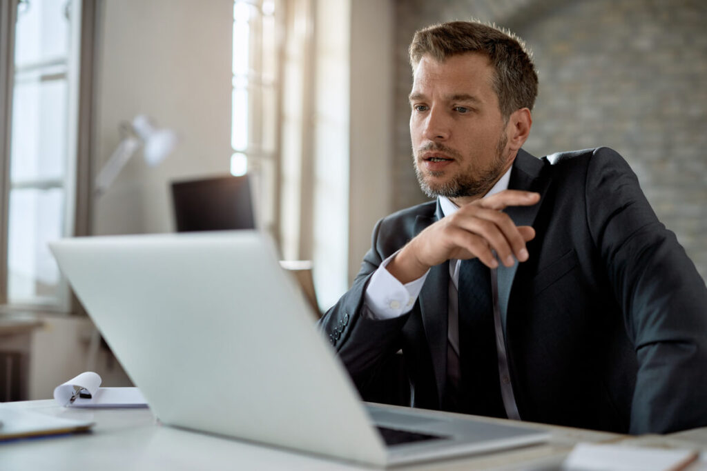 Dirigeant d'entreprise et responsable financier analysant un prévisionnel de trésorerie sur ordinateur.