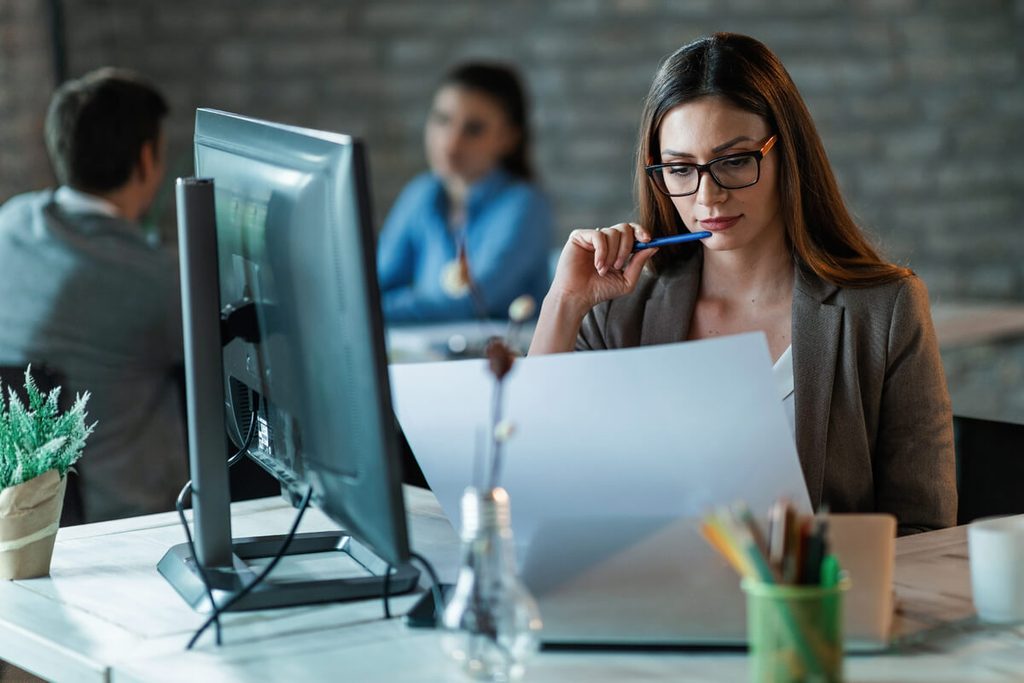 HR4YOU : présentation du logiciel RH et où trouver de vrais avis 3 Responsable des ressources humaines comparant les modules SIRH sur son ordinateur de bureau.