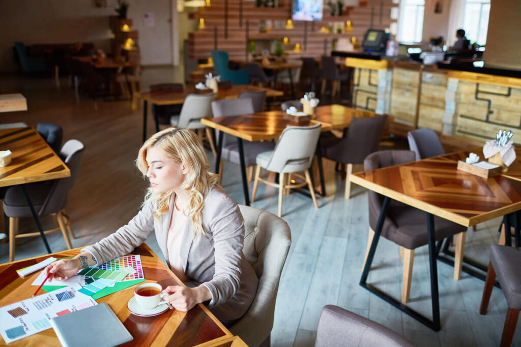 Salle moderne d'un restaurant en franchise avec clients attablés et équipe au comptoir de commande.