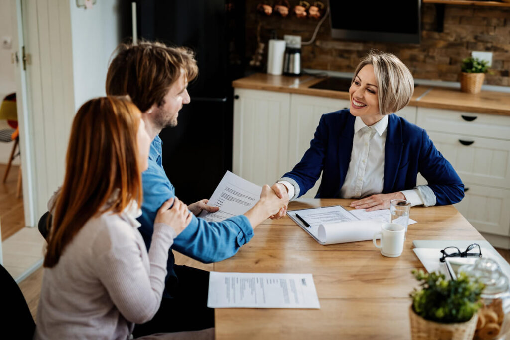 Assurance emprunteur : ce qu'il faut savoir avant de signer votre prêt immobilier 2 Emprunteur signant son offre de prêt immobilier et son contrat d'assurance emprunteur en agence bancaire.