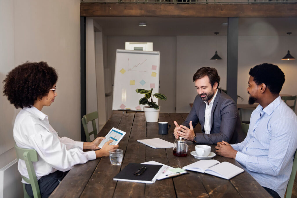 Échange stratégique autour d'une table entre un dirigeant de PME et un directeur externe à temps partagé.