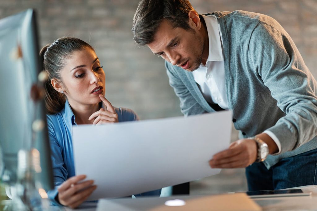 Chargé de clientèle analysant un relevé d'opérations et un motif de rejet de virement.