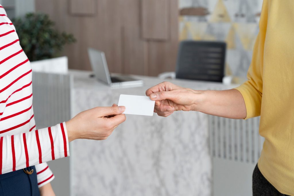 Deux professionnels échangeant leurs cartes de visite lors d'un événement de réseautage d'affaires.