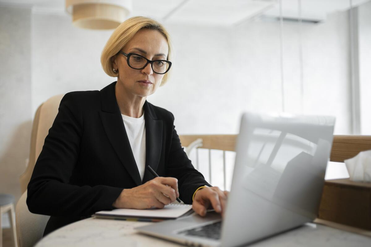 Dirigeant de PME suisse validant des factures numériques sur une plateforme partagée avec son fiduciaire.
