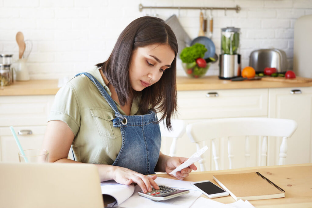 Comment arrondir ses fins de mois : 12 solutions concrètes, rentables et légales 2 Personne calculant ses compléments de revenus mensuels avec des billets d'euros et une calculatrice.