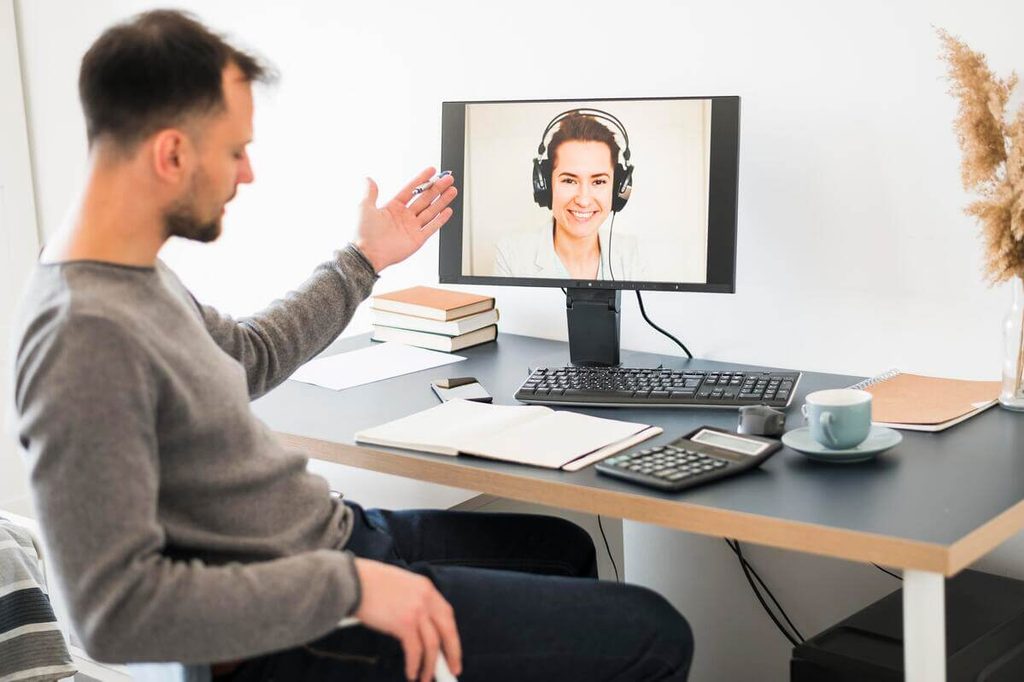 Espace de télétravail à domicile d'un agent de relation client avec double écran d'ordinateur.